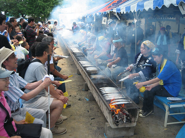 Nhiều hàng người xếp hàng chờ đến lượt được thưởng thức cá thu đao nướng phí trong lễ hội tại Meguro